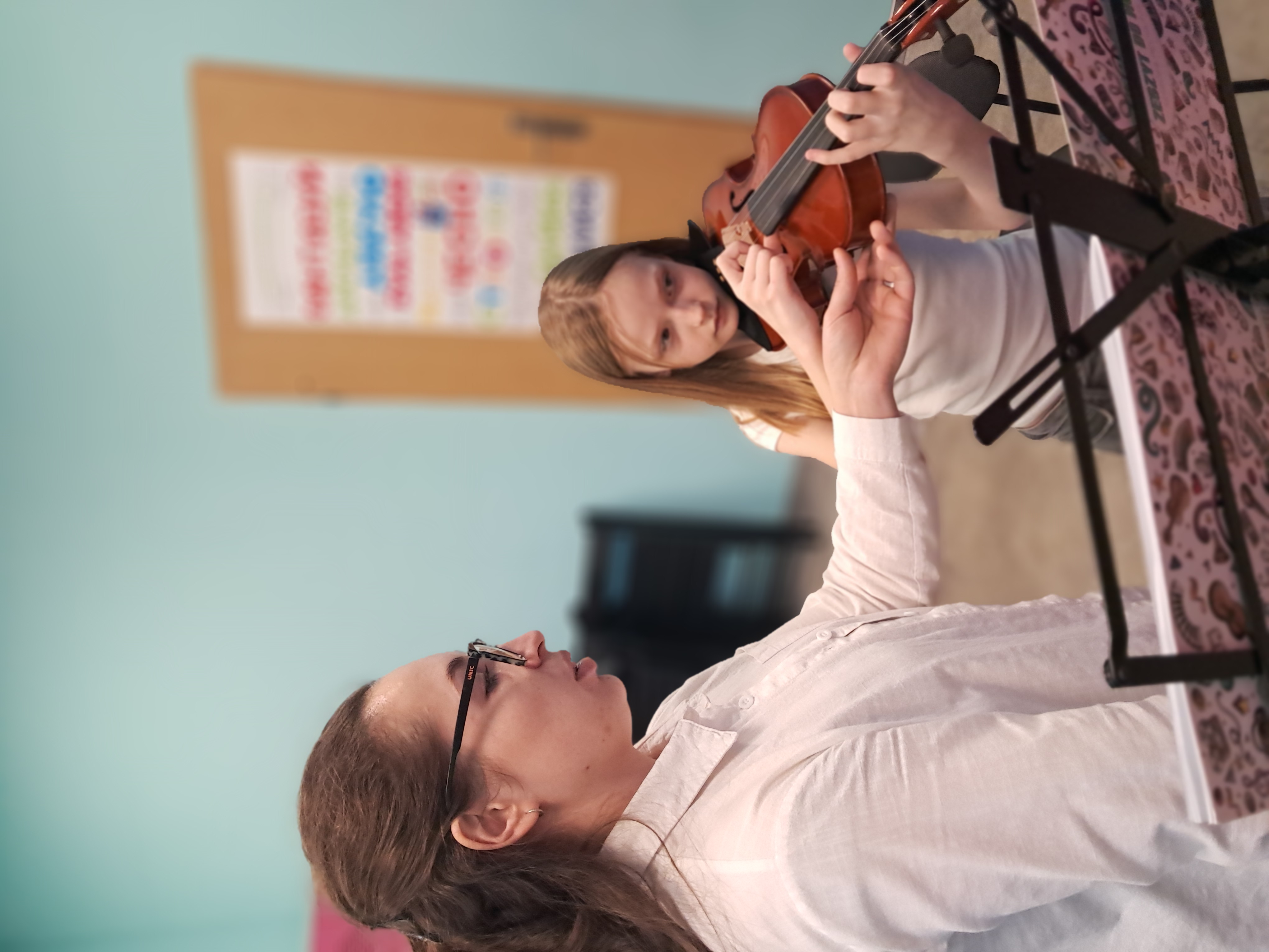 Nauczyciel z uczennicą grającą na skrzypcach