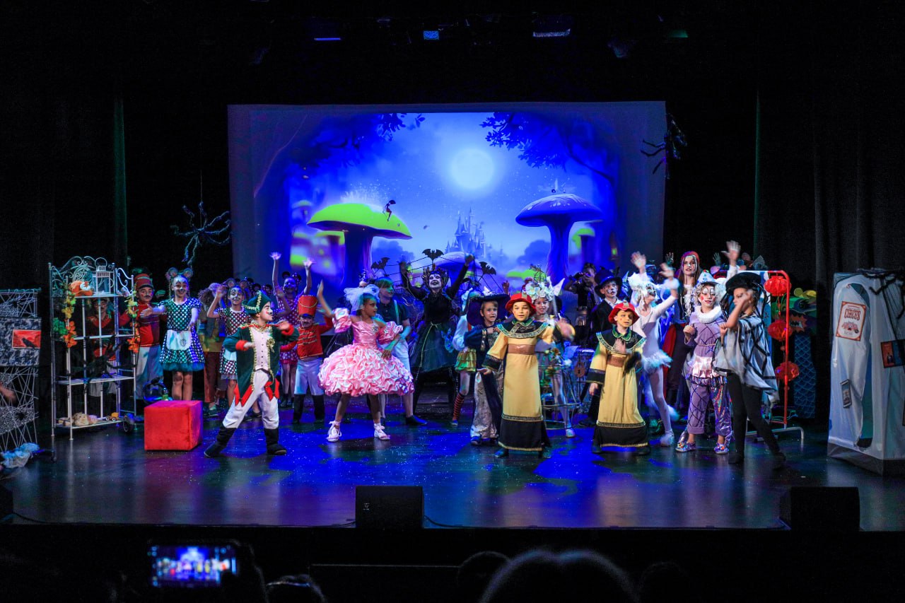 Scena teatralna i dzieci z musicalu